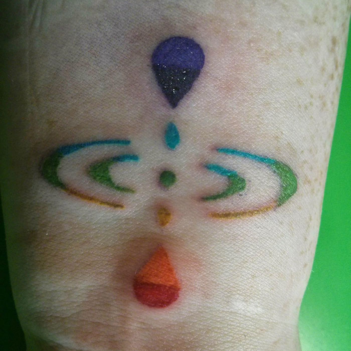 Rainbow mindfulness tattoo on a hand